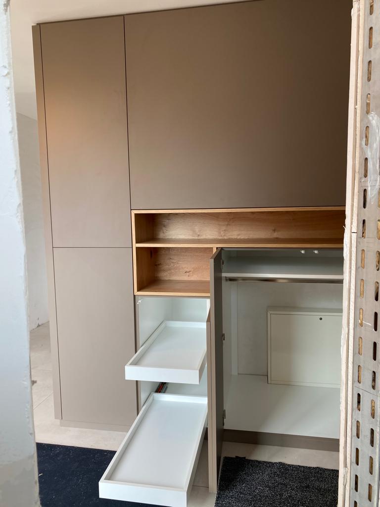 Moderne Küchenzeile mit einem offenen Regal und Schubladen in Holz- und Weißtönen.